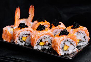 Sushi roll with fried salmon, shrimp and black caviar