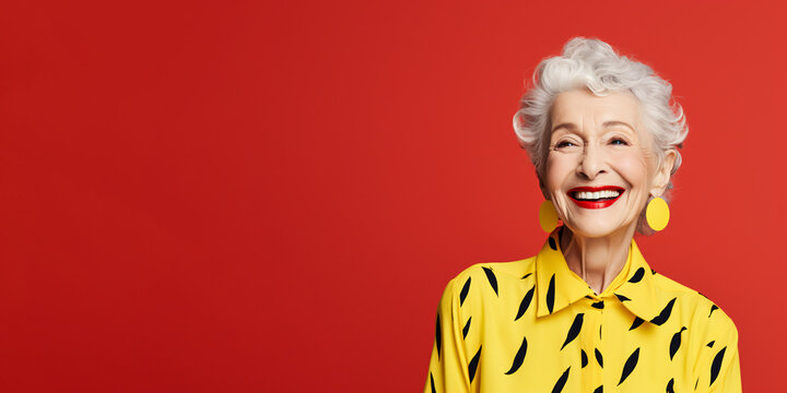 Energetic senior woman isolated on solid red background.