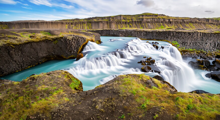amazing and beautiful waterfall falling from a cliff in iceland - obrazy, fototapety, plakaty