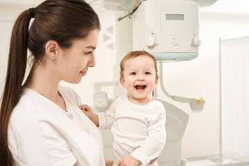 Young mom and joyful infant before radiography procedure