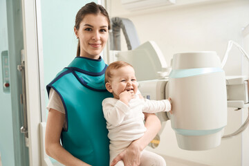 Smiling woman with her baby before radiography procedure