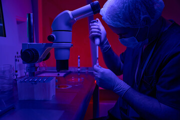 Genetic laboratory researcher taking sample from test tube