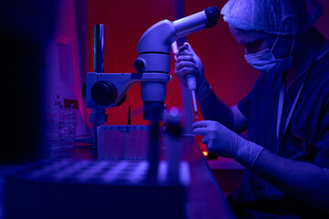 Science laboratory engineer adding cells to test tubes
