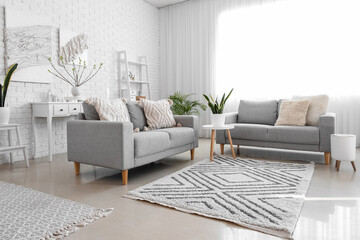 Stylish interior of light living room with posters on wall