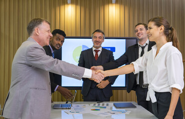 professional business people shaking hands after meeting in boardroom,modern business leadership team conference the solution strategy of financial investment data via technology screen tv digital