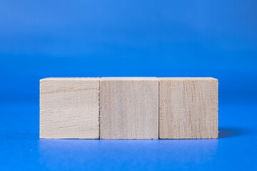 【合成素材】青色の背景に置かれた3つの木製のブロック