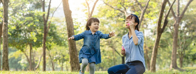 happy holidays, Mum and daughter play together in the park.