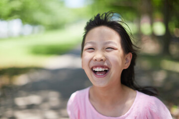 夏の公園で遊んでいる可愛い女の子の笑顔 - obrazy, fototapety, plakaty