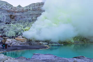 Fototapeta premium Beautiful landscape mountain and turquoise lake with smoke sulfur in the morning. The world's largest acidic lake,inside the crater of Kawah Ijen volcano in East Java, Indonesia. 