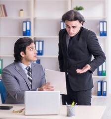 Two young employees working in the office