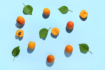 Fresh apricots with leaves on blue background
