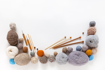 Knitting as a hobby. Wooden knitting needles, crochet hooks and different types of woolen yarn in...