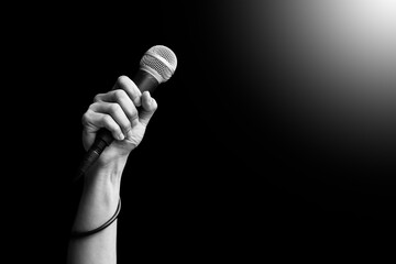 close up microphone in hand of singer raised his hand all the way up in live concert. singing...