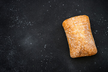 Ciabatta bread on black background. Top view with copy space.