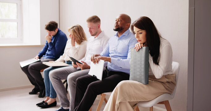 People Bored While Sitting On Chair Waiting For Job Interview