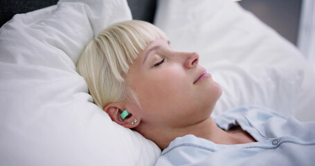 Obraz na płótnie Canvas Woman Sleeping With Earplugs In Her Ears