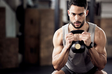 Fitness, exercise and man squat with a kettlebell at gym for a training workout with focus. Serious male athlete or bodybuilder with weights for strong muscle, power and motivation with mockup space