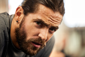 Tired, portrait and a man in the gym with a break from fitness, breathing and training. Rest,...