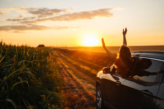 Car and summer with a female tourist taking a scenic drive at sunset. Lifestyle, travel, tourism, nature, active life.
