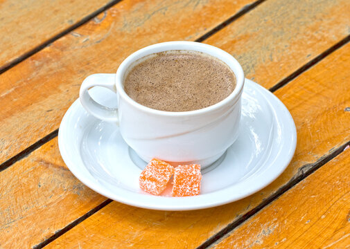 A cup of terebinth coffee, a local hot drink of Kozan, served with some cubes of orange delights
