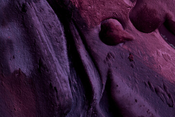 Decorative purple putty background. Wall texture with filler paste applied with spatula, chaotic...