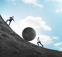 Teamwork example with business people pushing stone to top