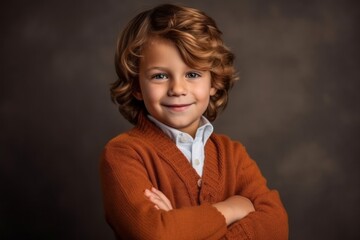 Portrait of a cute little boy with red curly hair. Studio shot.