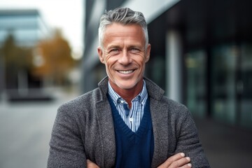 Obraz premium Portrait of smiling mature man standing with arms crossed in city street
