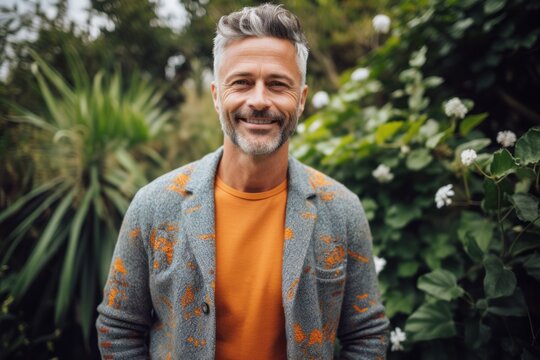 Medium shot portrait photography of a cheerful man in his 40s that is wearing a chic cardigan against a garden or botanical background . Generative AI