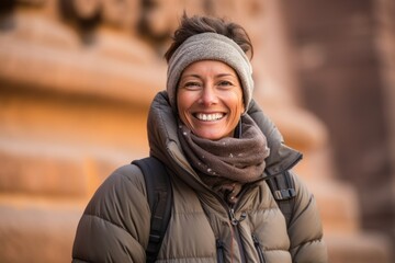Portrait of a smiling middle-aged woman wearing warm clothing outdoors