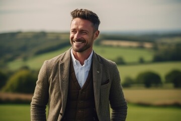 Portrait of a handsome man smiling at camera while standing in the countryside