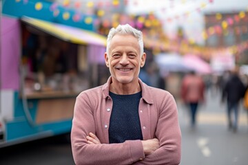 Portrait of smiling senior man with arms crossed at street food festival