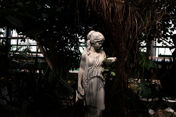 Statue of a woman with a flower in her hand in the garden