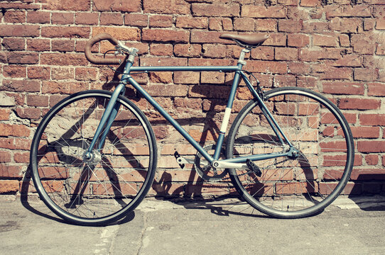 Retro fixed gear bicycle near brick wall in the city. Vintage toned image