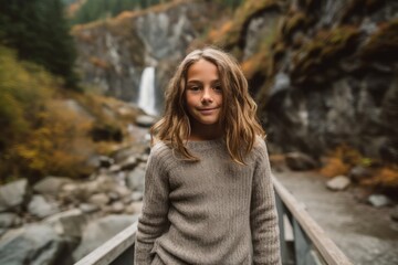 Fototapeta premium Beautiful girl on the background of a waterfall in the autumn forest