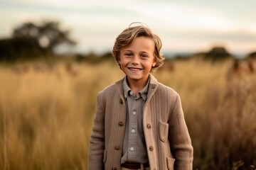 Portrait of a smiling little boy in a wheat field at sunset