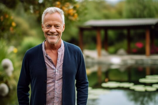 Medium shot portrait photography of a satisfied man in his 50s that is wearing a chic cardigan against a tranquil koi pond with fish and water lilies background . Generative AI