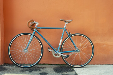 Fototapeta na wymiar Retro fixed gear bicycle on brown concrete wall background