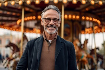 Fototapeta premium Medium shot portrait photography of a satisfied man in his 50s that is wearing a chic cardigan against an old-fashioned carousel in motion at a city square background . Generative AI