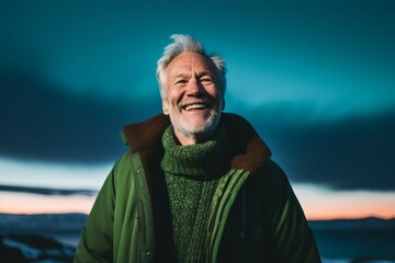Portrait of senior man with grey hair and beard smiling at camera in winter