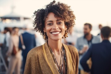 Portrait of beautiful young African American woman with curly hair, looking at camera and smiling while standing outdoors.