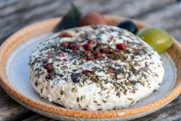 French fresh white soft goat cheeses with topping made with herbs, paprika, indian curry,  chives and dried tomatoes