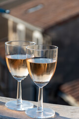 French cold rose dry wine from Provence in two glasses in sunny day with view on old roofs of Arles town in sunny day