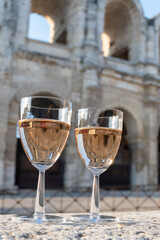 French rose dry wine from Provence in two glasses in sunny day with view on old streets of Arles...