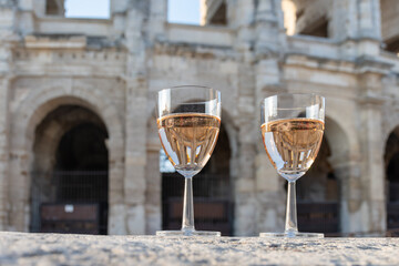 French rose dry wine from Provence in two glasses in sunny day with view on old streets of Arles...