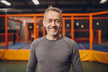 Portrait of a smiling mature man standing on a trampoline.