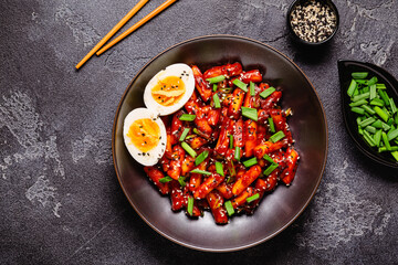 Tteokbokki, Teopokki fried rice cake in black bowl.