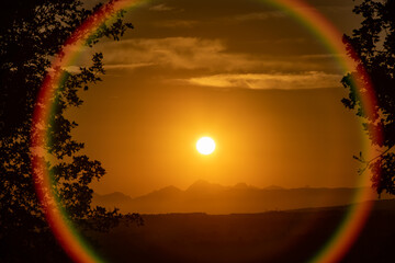 Sun setting over Parco Alpi Apuane mountains with a circular lens flare