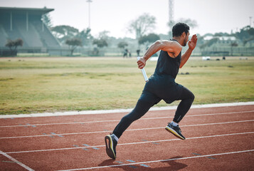 Stadium, man relay running and athlete on a runner and arena track for sprint race training. Fast, run and sports exercise of a male person in marathon for fitness and workout outdoor on a field - obrazy, fototapety, plakaty