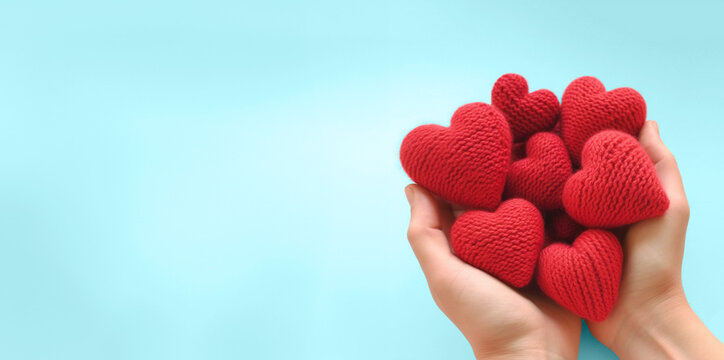 Hands holding knitted red hearts, love and emotion concept, good hearted person, help and charity, generative AI
